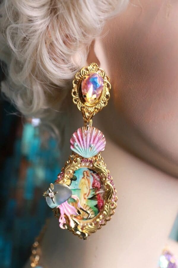 A woman wearing colorful earrings with shells and sea animals.