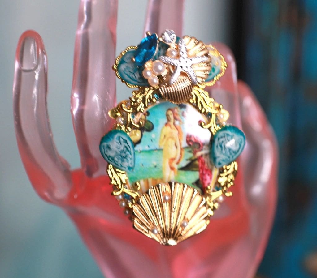 A pink hand with a ring on it