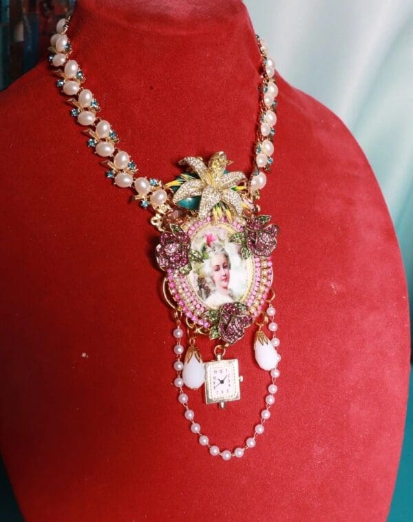 A red velvet display with a necklace and some pearls