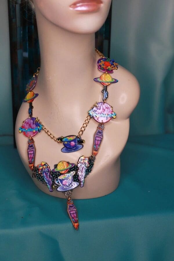 A necklace is shown on display in front of a mannequin.