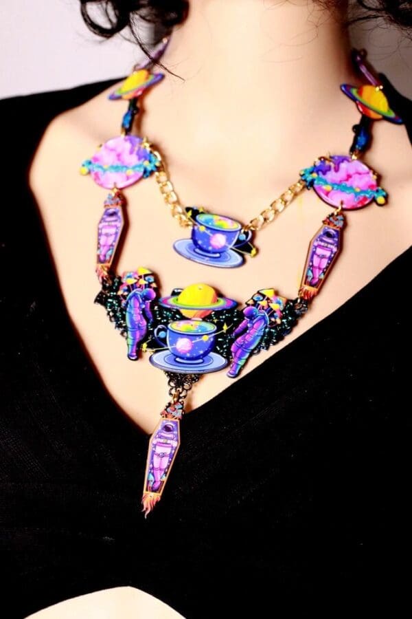 A woman wearing a necklace with purple and blue beads.
