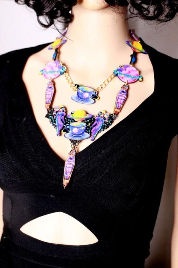 A woman wearing a necklace with purple and yellow beads.