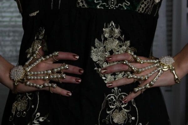 A woman with her hands covered in pearls.