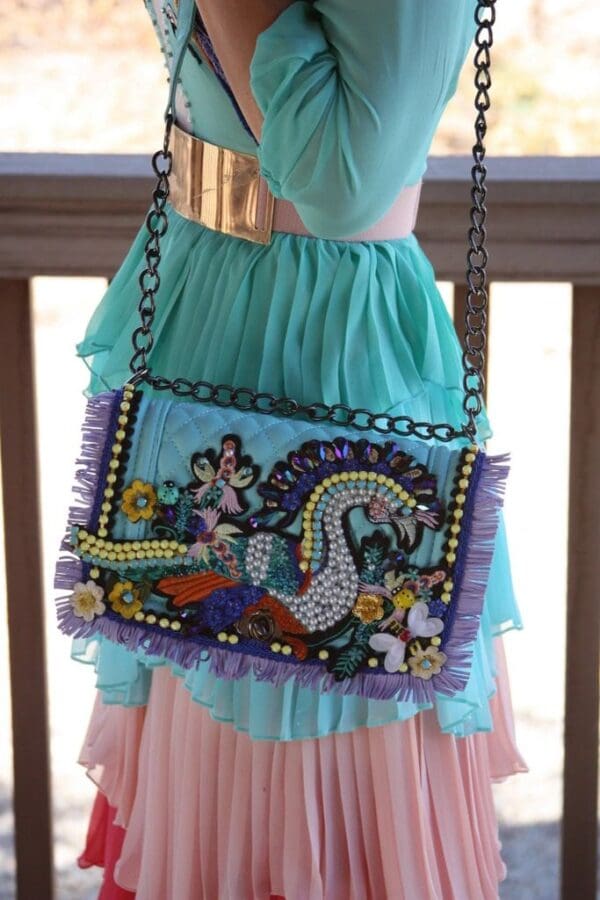A woman in a blue dress holding onto a bag