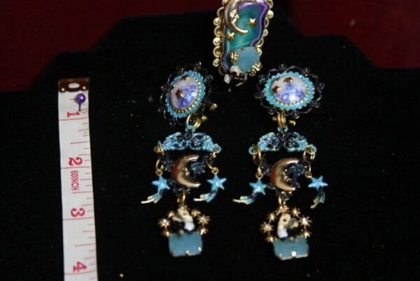 A pair of earrings with blue and gold designs.