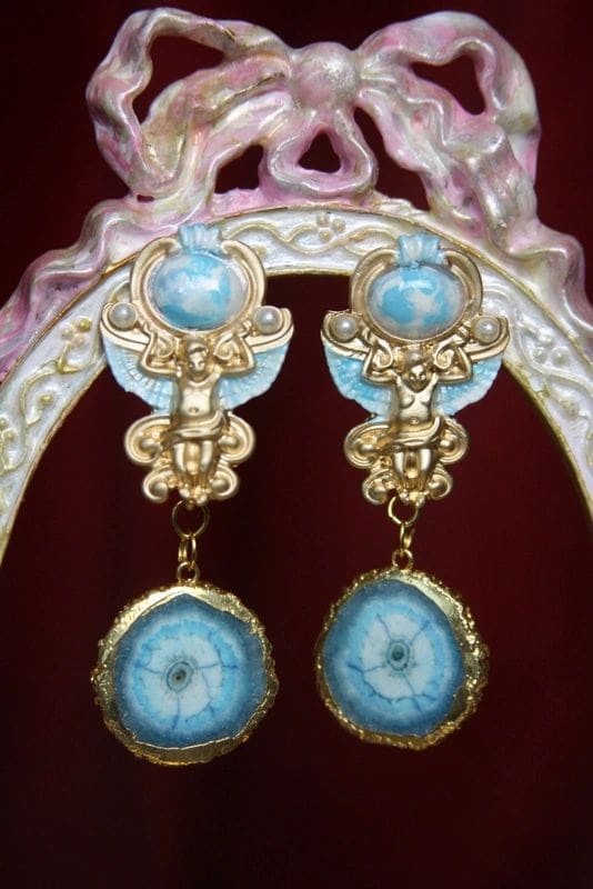 A pair of earrings with blue and gold designs.