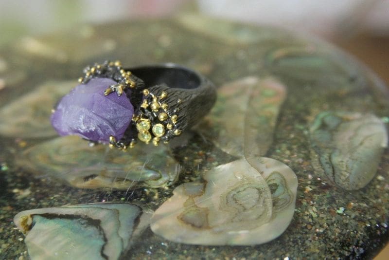 A purple ring sitting on top of rocks.