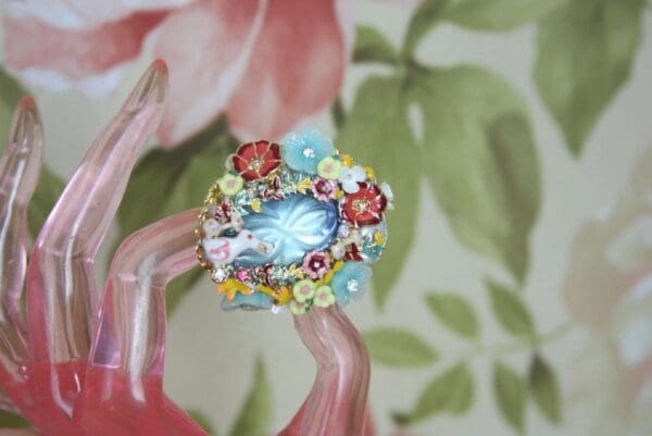 A ring with flowers and a blue stone.