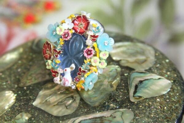 A ring with flowers and leaves on top of some rocks
