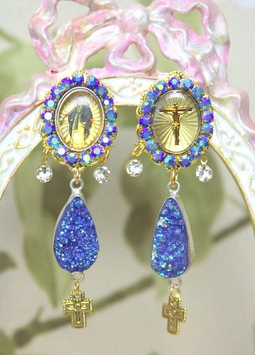 A pair of earrings with blue stones and gold frames.