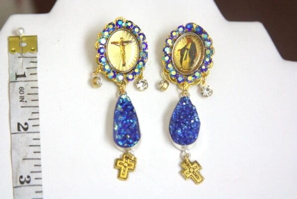 A pair of earrings with blue stones and crosses.