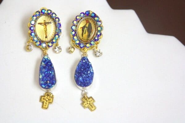 A pair of earrings with blue stones and crosses.