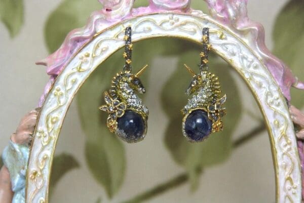 A pair of earrings with blue stones on them.