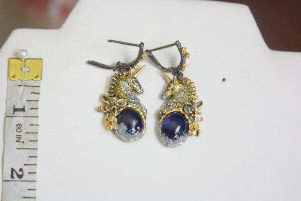 A pair of earrings with gold and blue stones.