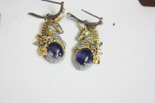 A pair of earrings with gold and silver details.