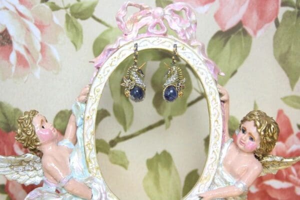 A pair of earrings hanging from the side of a mirror.