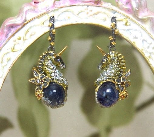 A pair of earrings with blue stones and gold accents.