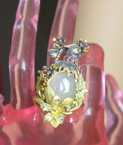 A pink hand with a ring on top of it