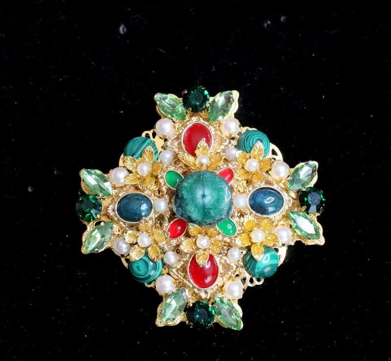 A brooch with pearls and stones on it