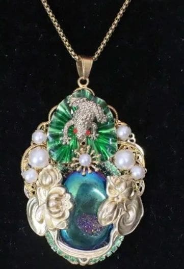 A necklace with a frog on it and pearls