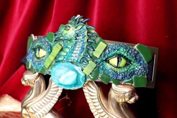 A close up of the dragon mask on a red curtain