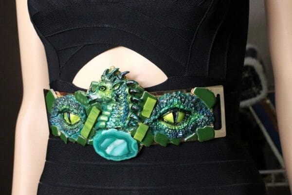 A close up of the belt with green eyes