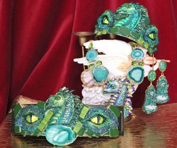 A green dragon mask and hat on a table.