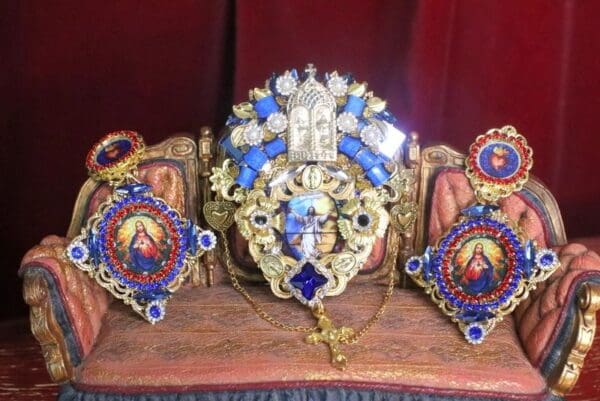 A set of three religious medals sitting on top of a table.