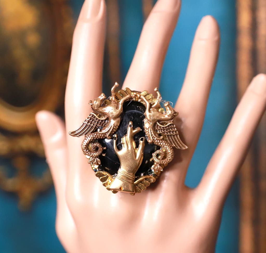 A hand is holding onto the ring of jewelry