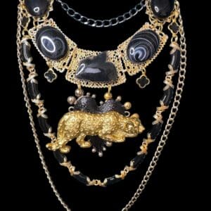 A black and gold necklace with a bear on it.