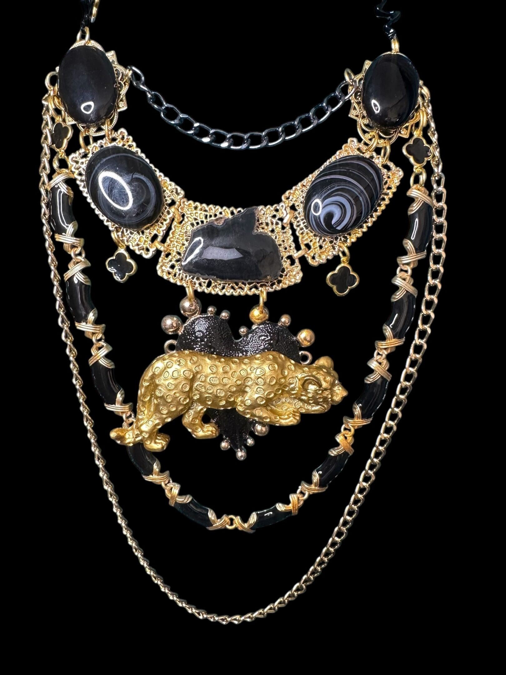 A black and gold necklace with a bear on it.