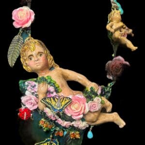 A statue of a child sitting on a swing.