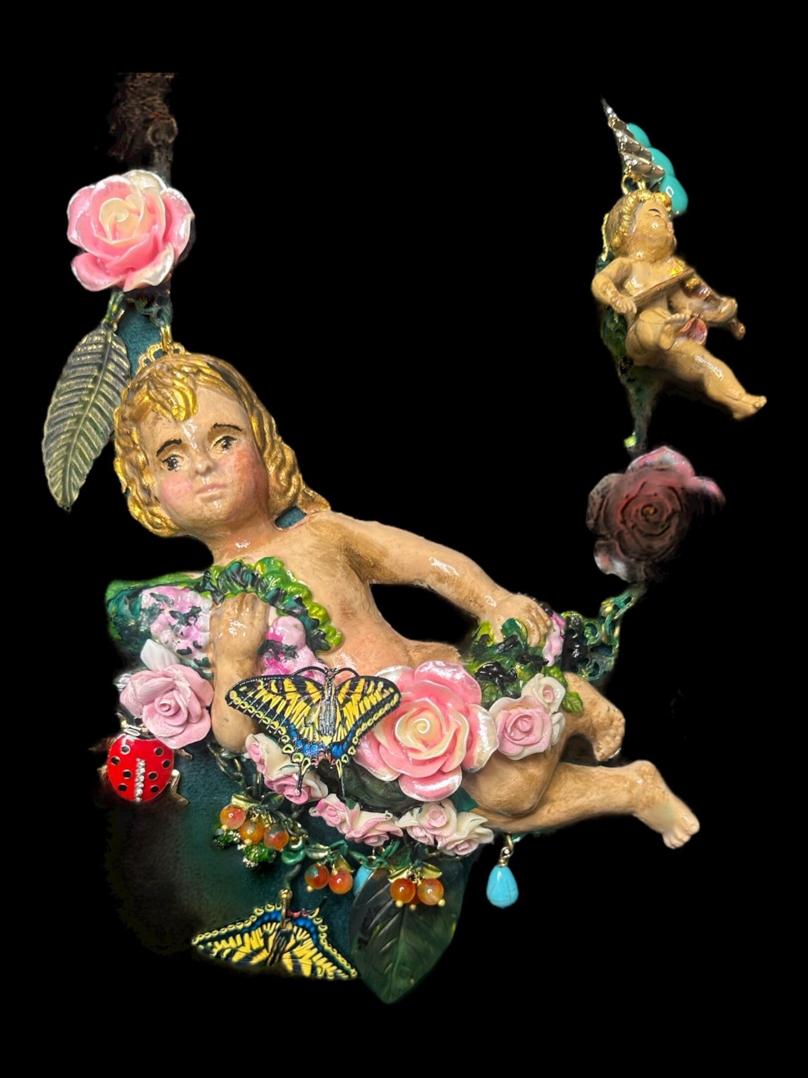 A statue of a child sitting on a swing.