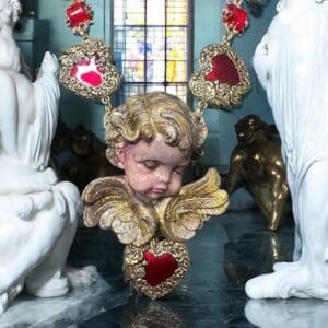 A statue of an angel with red hearts around it.