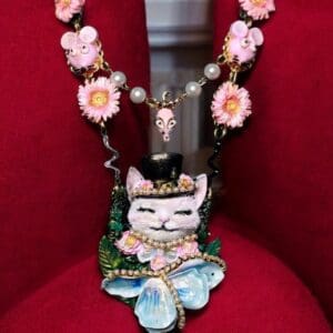 A necklace with a cat on it sitting in a chair.