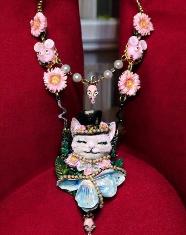 A necklace with a cat on it sitting in a chair.