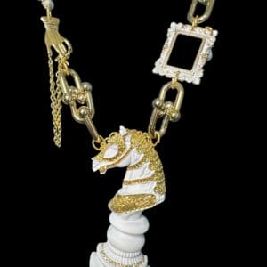 A white horse necklace with gold and diamond accents.