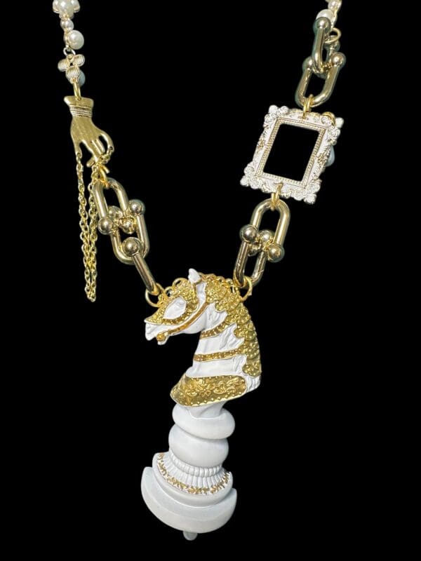 A white horse necklace with gold and diamond accents.