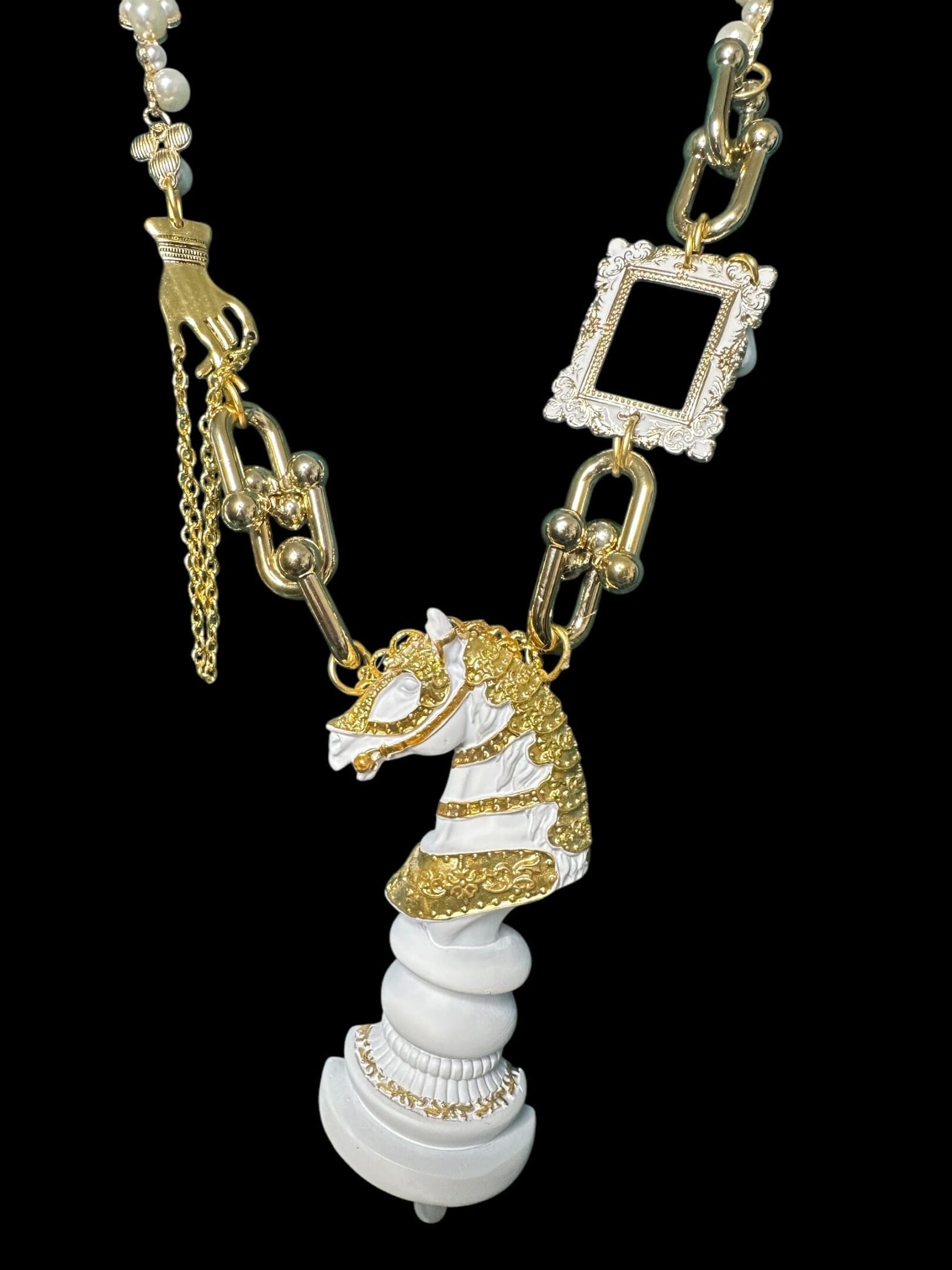A white horse necklace with gold and diamond accents.