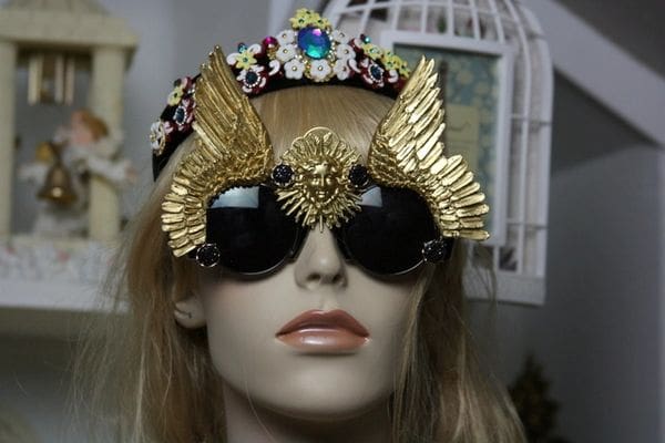 A mannequin wearing gold sunglasses and a crown.