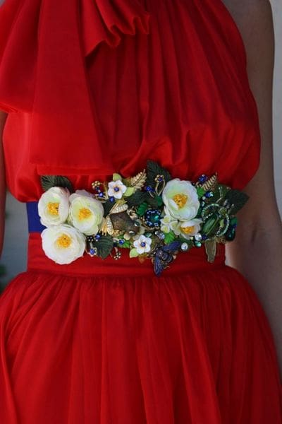 A woman wearing red dress with flowers on it.