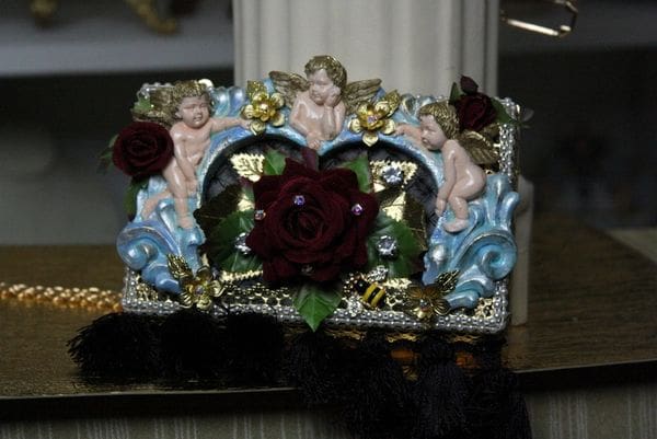A picture frame with angels and roses on it.