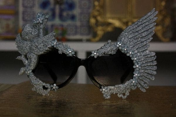 A pair of sunglasses with wings made out of rhinestones.