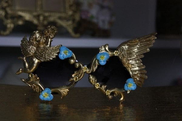 A pair of gold frames with blue flowers on top.