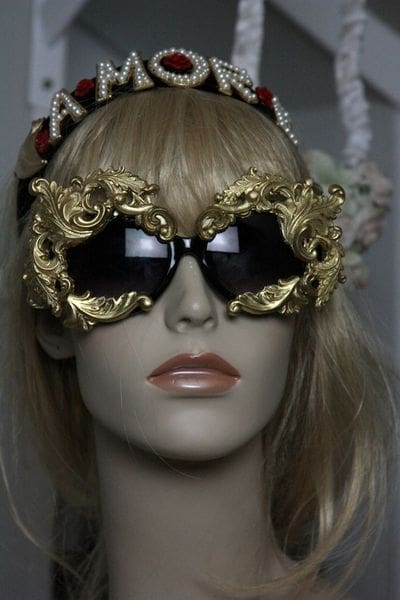 A mannequin wearing gold sunglasses with ornate frames.