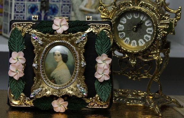 A picture of a woman in a frame next to two clocks.