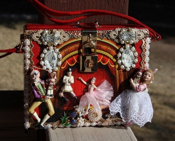 A red purse with some figurines on it