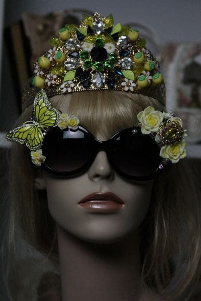 A mannequin wearing sunglasses and a crown.