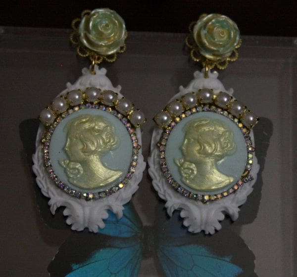 A pair of earrings with gold and white designs.