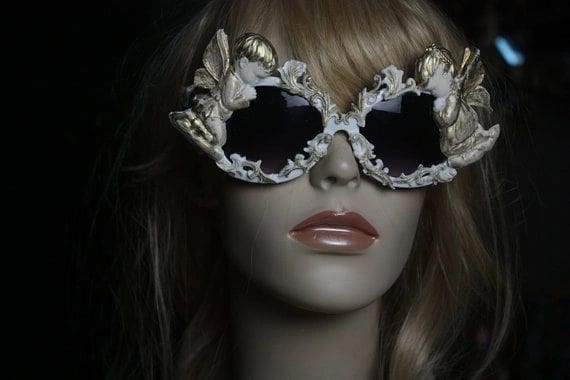 A mannequin wearing sunglasses with gold leaves on them.